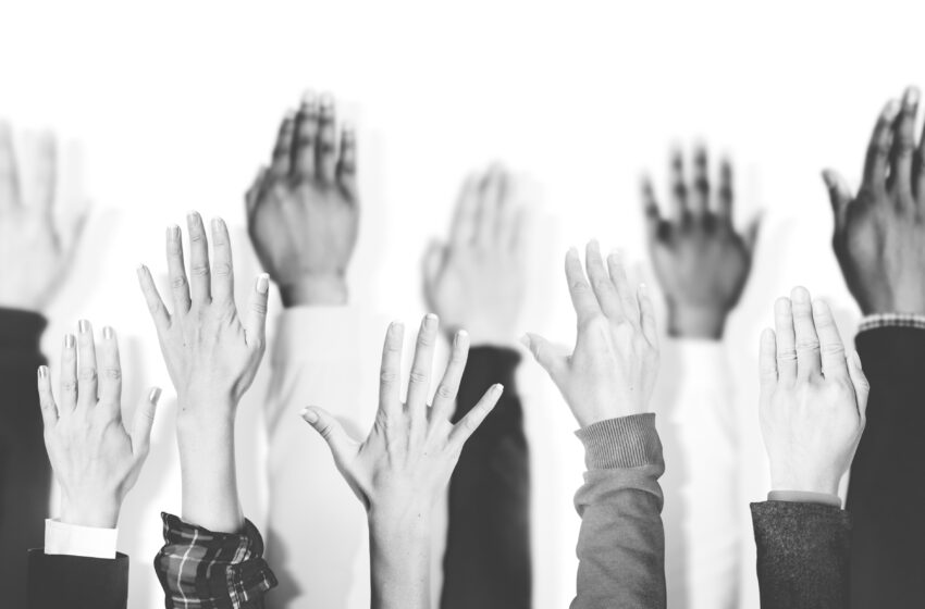 multiethnic group of hands raised