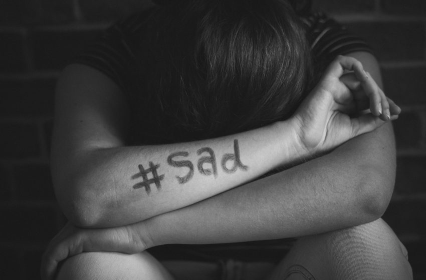 girl with hashtag sad written her arm
